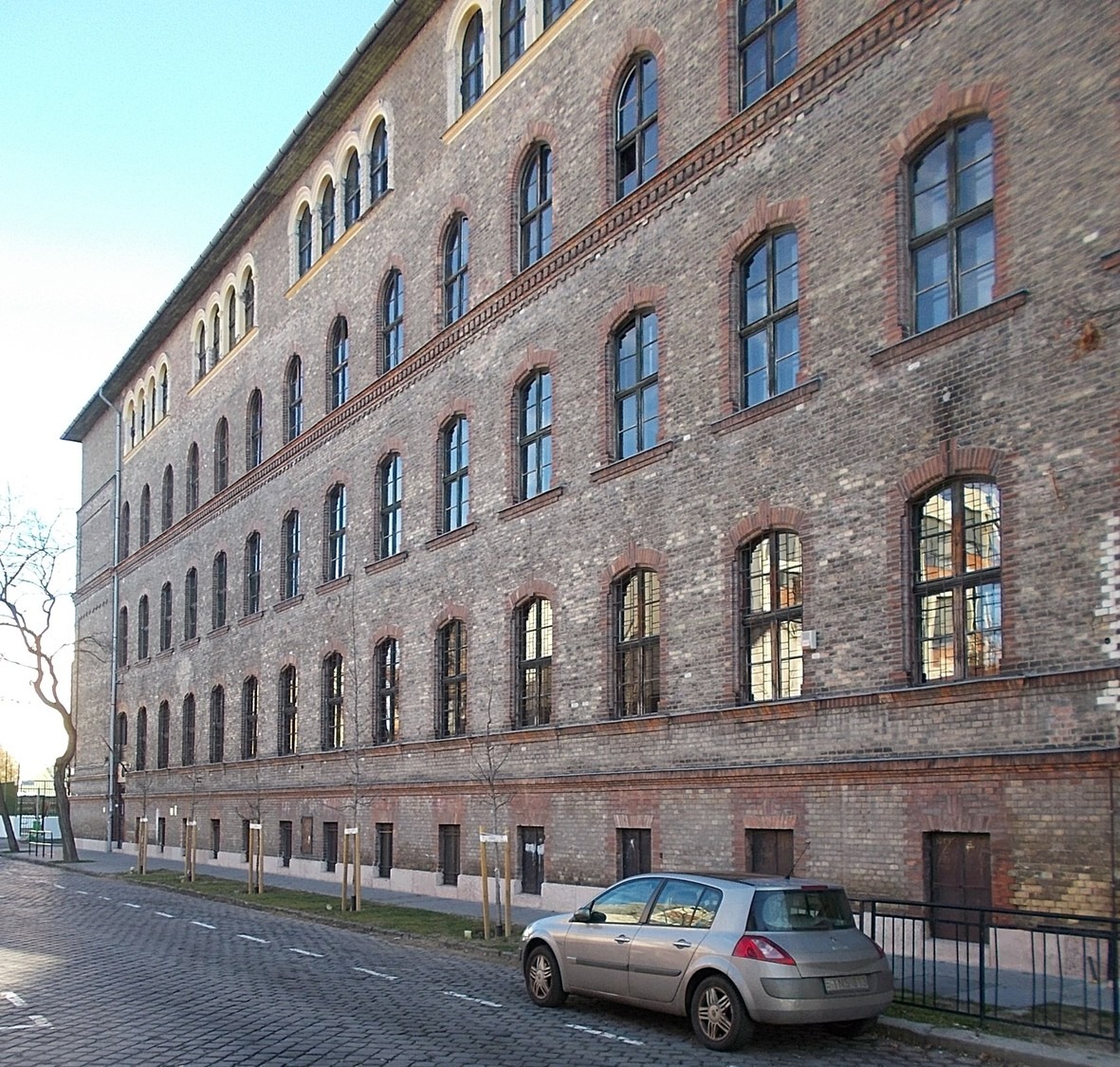 A car parked in front of a large brick building

Description automatically generated with medium confidence